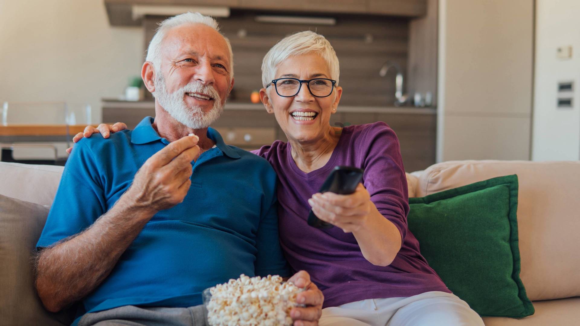 elderly couple eating popcorn