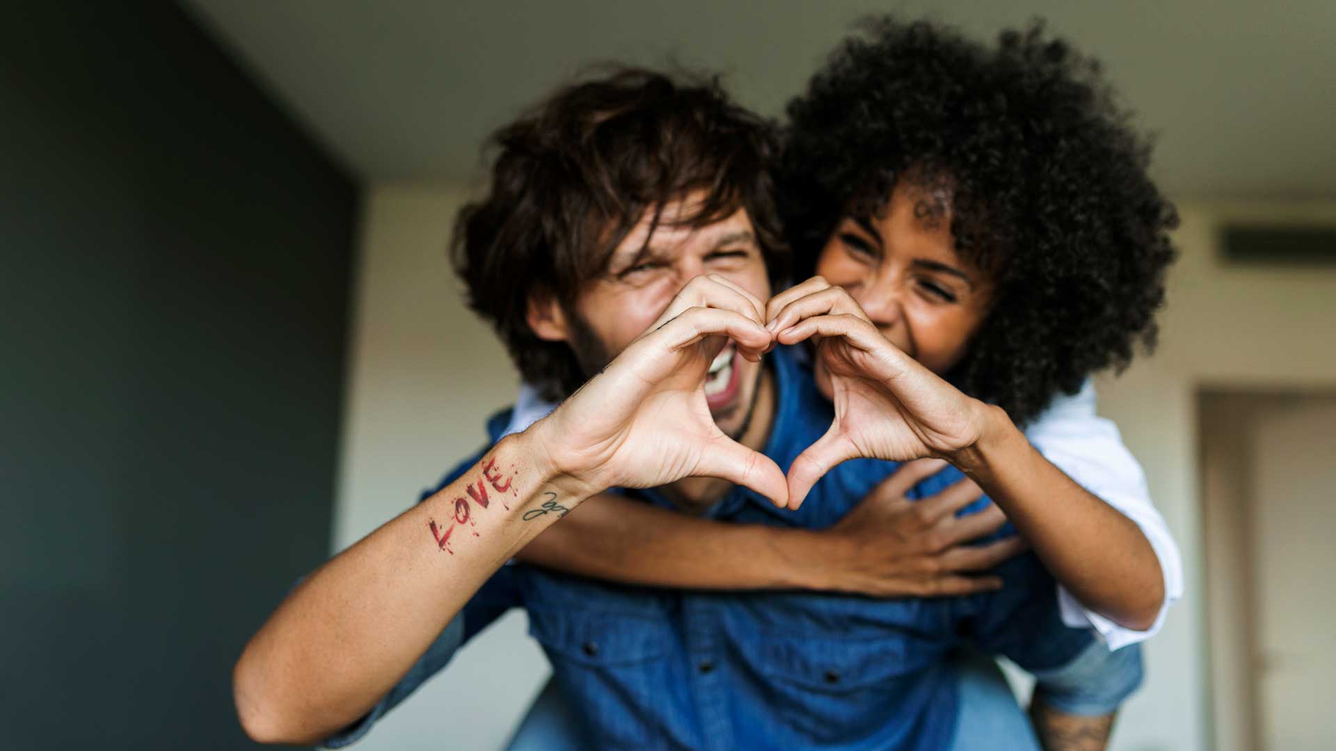 young couple making heart with hands